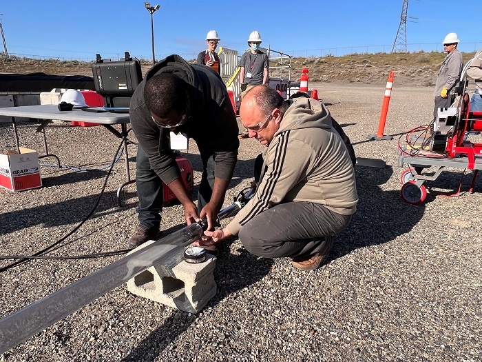Florida International University research scientists Mackenson Telusma, left, and Anthony Abrahao deploy a pipe crawler during a field test at the Hanford Site.